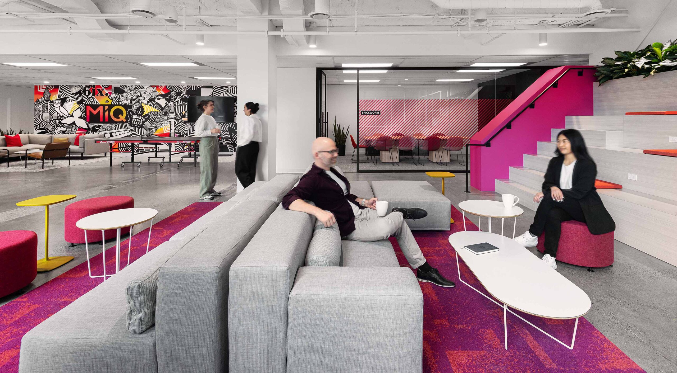 Media company office - vibrant open collab area with lounge seating with a view of boardroom